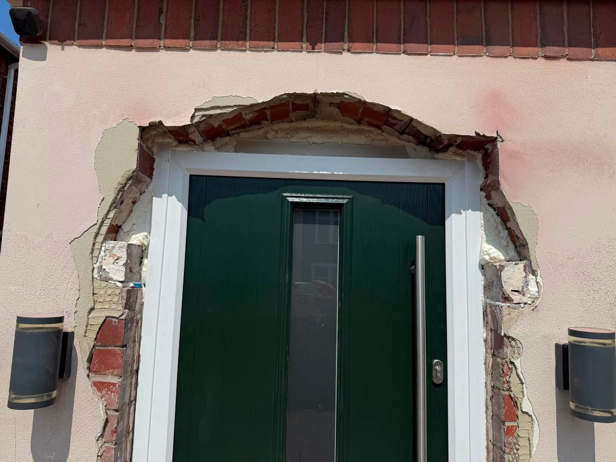 External render cut back around a front door, exposing the brick