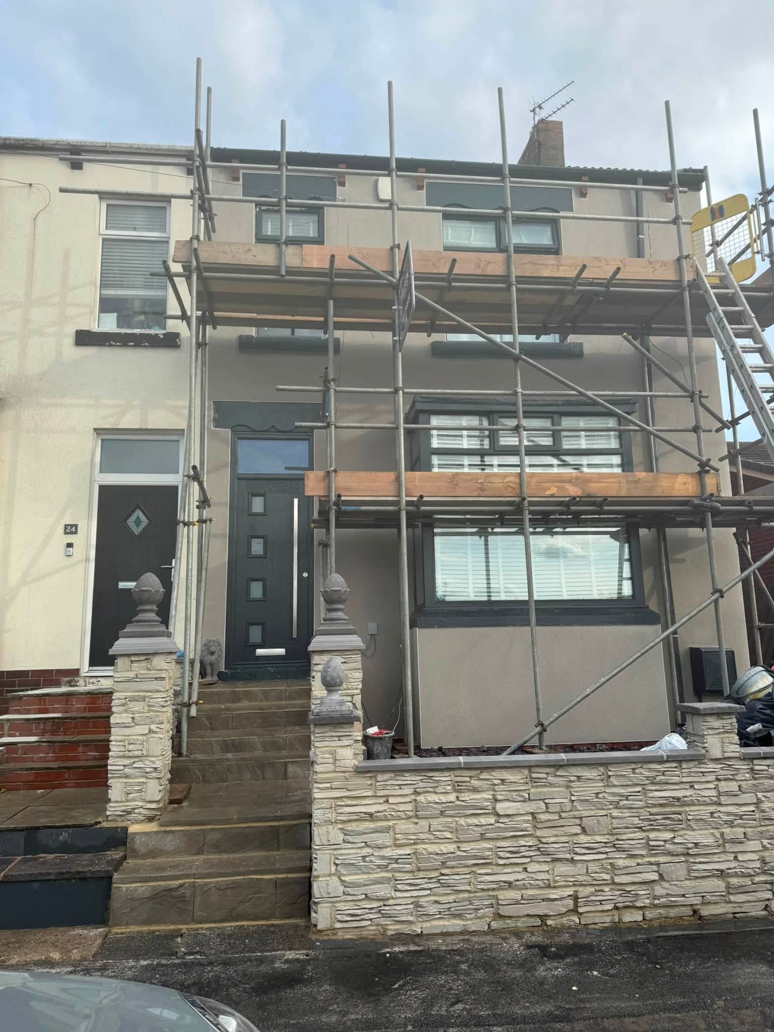Terraced house with fresh external render and scaffolding