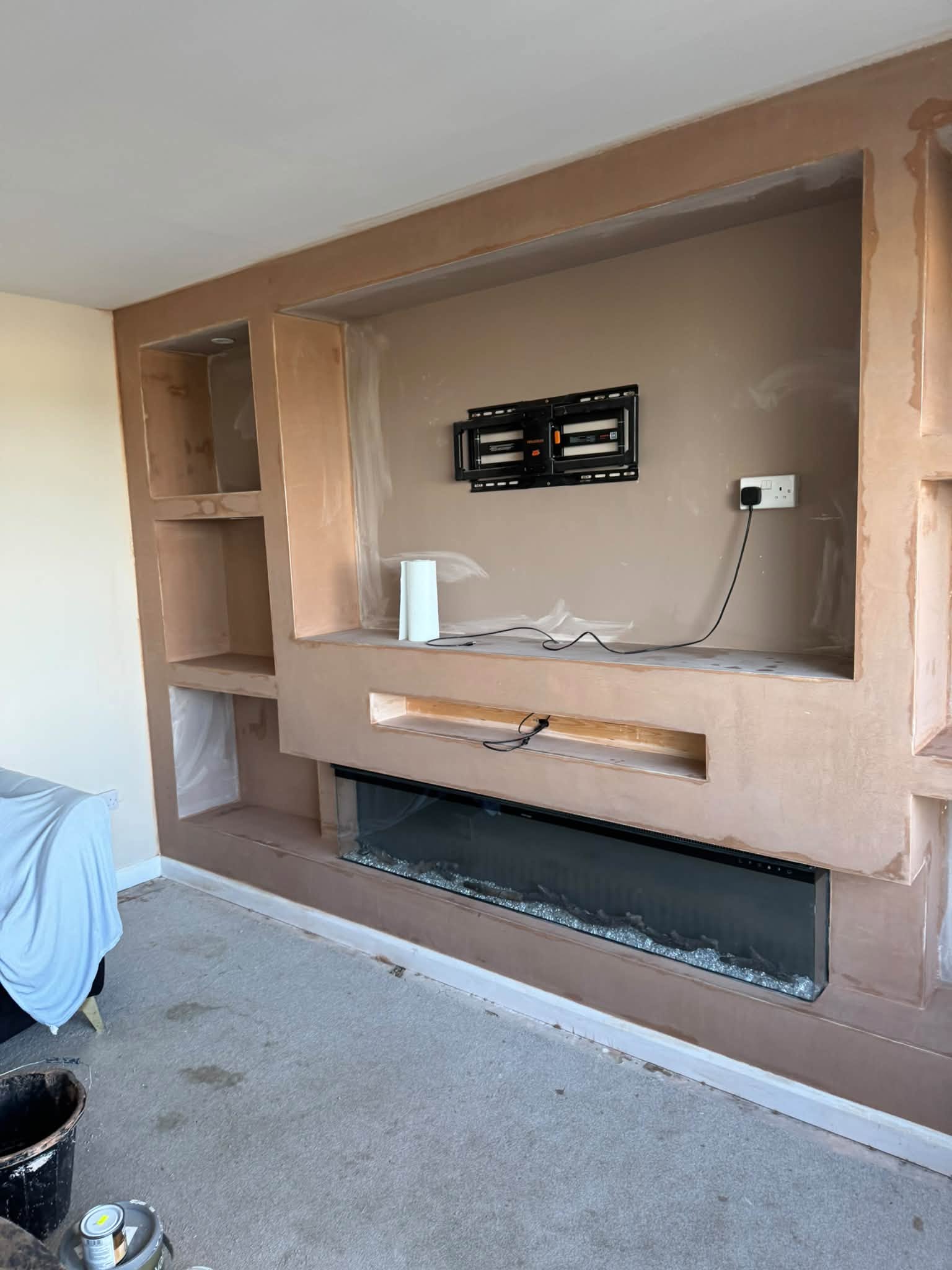 Media wall with a fireplace, shelves and a television bracket